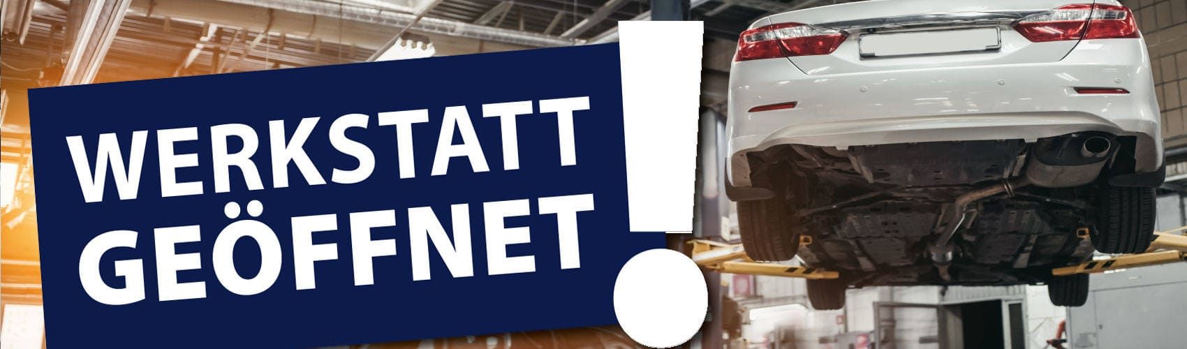 Ein Schild mit der Aufschrift „Werkstatt geöffnet“ neben einem Auto