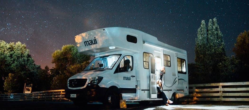 Ein weißes Wohnmobil ist unter einem sternenklaren Nachthimmel geparkt.