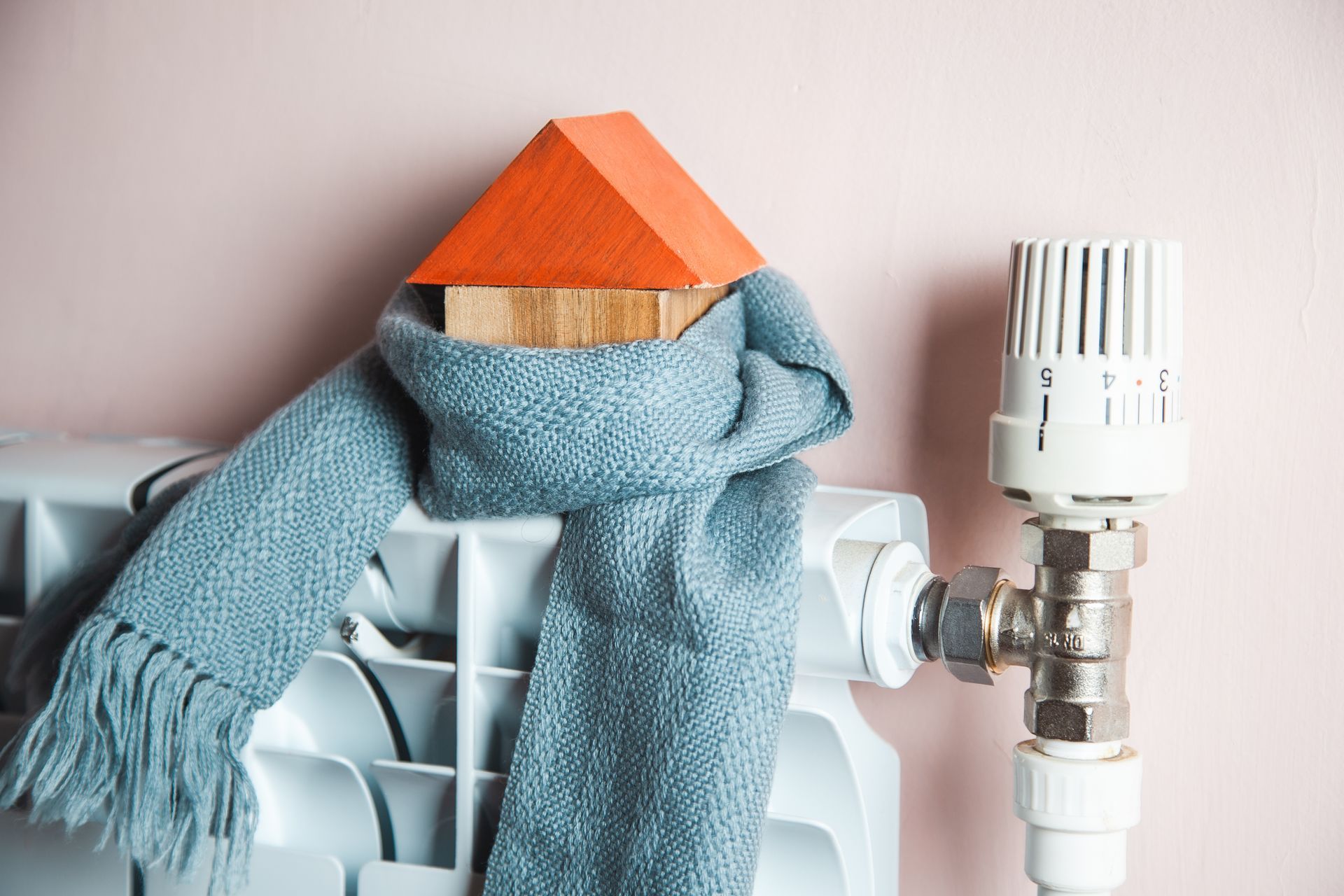 Une maison en bois entourée d'une écharpe sur un radiateur