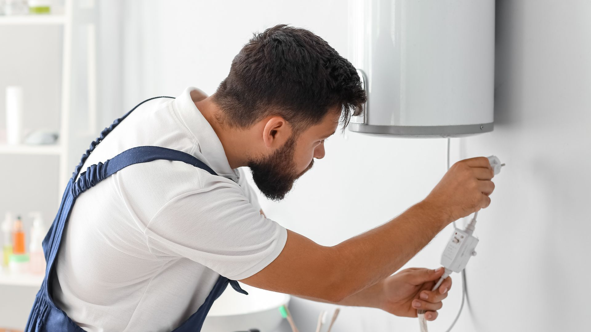 Un monsieur tient une prise d'un chauffe-eau