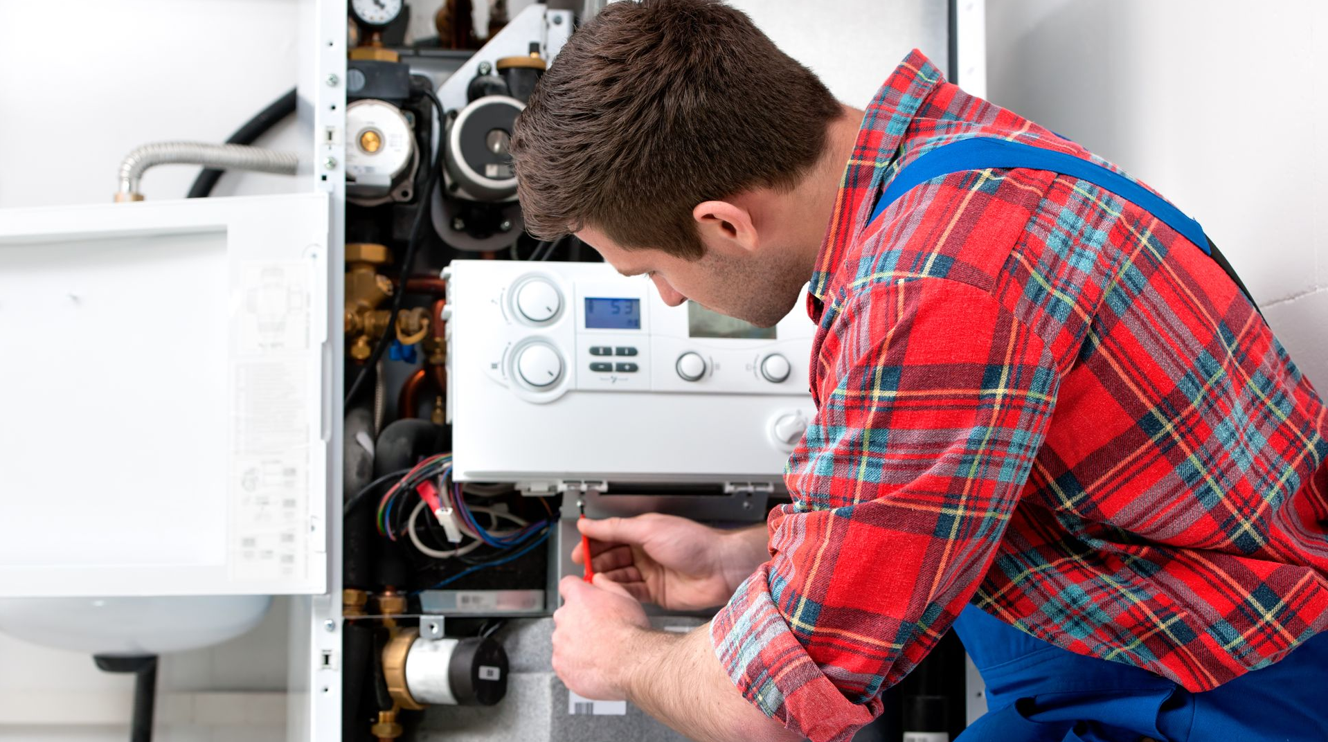 Un monsieur en train de dépanner une chaudière