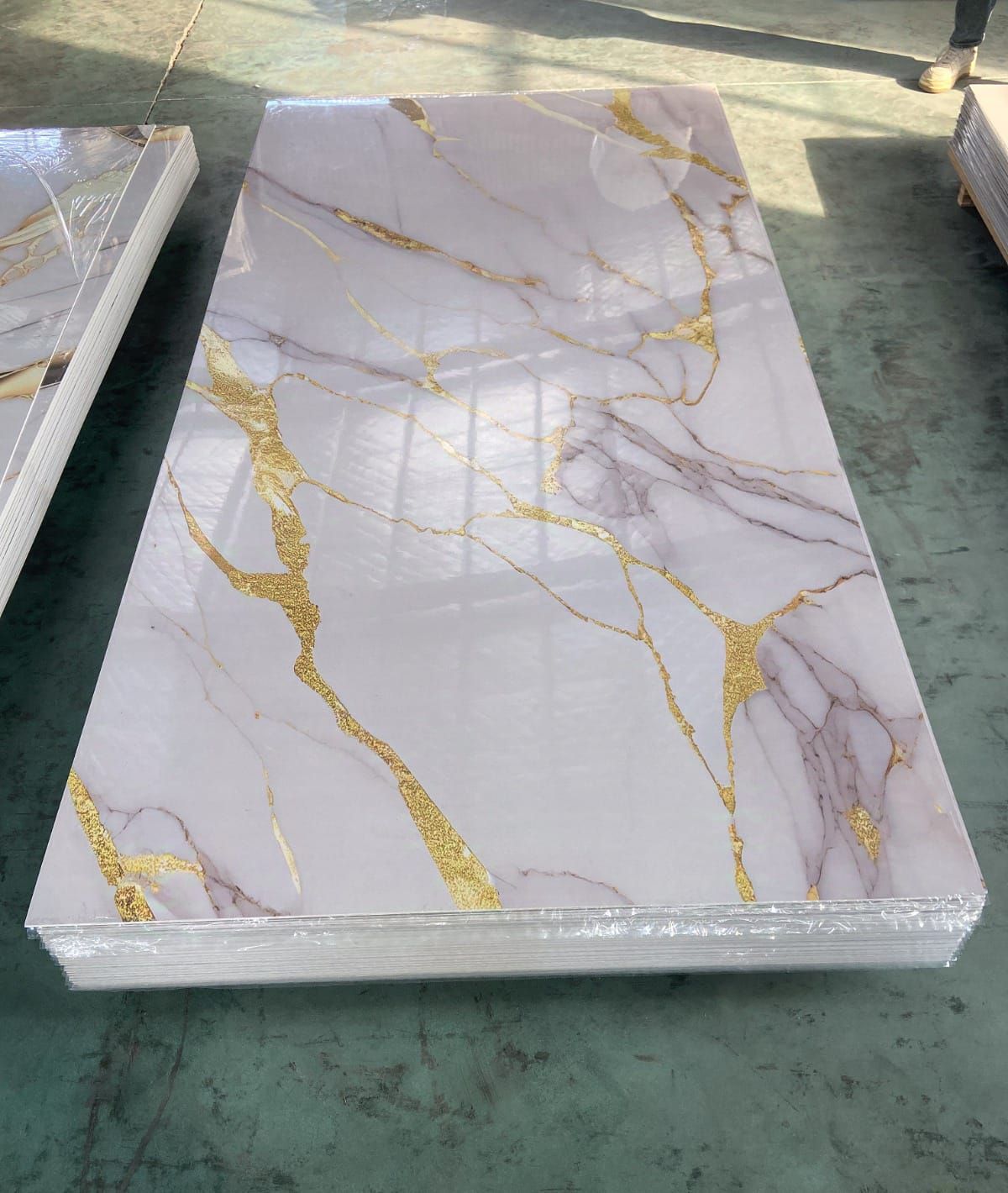 Una baldosa de mármol blanco con vetas doradas reposa sobre una mesa.