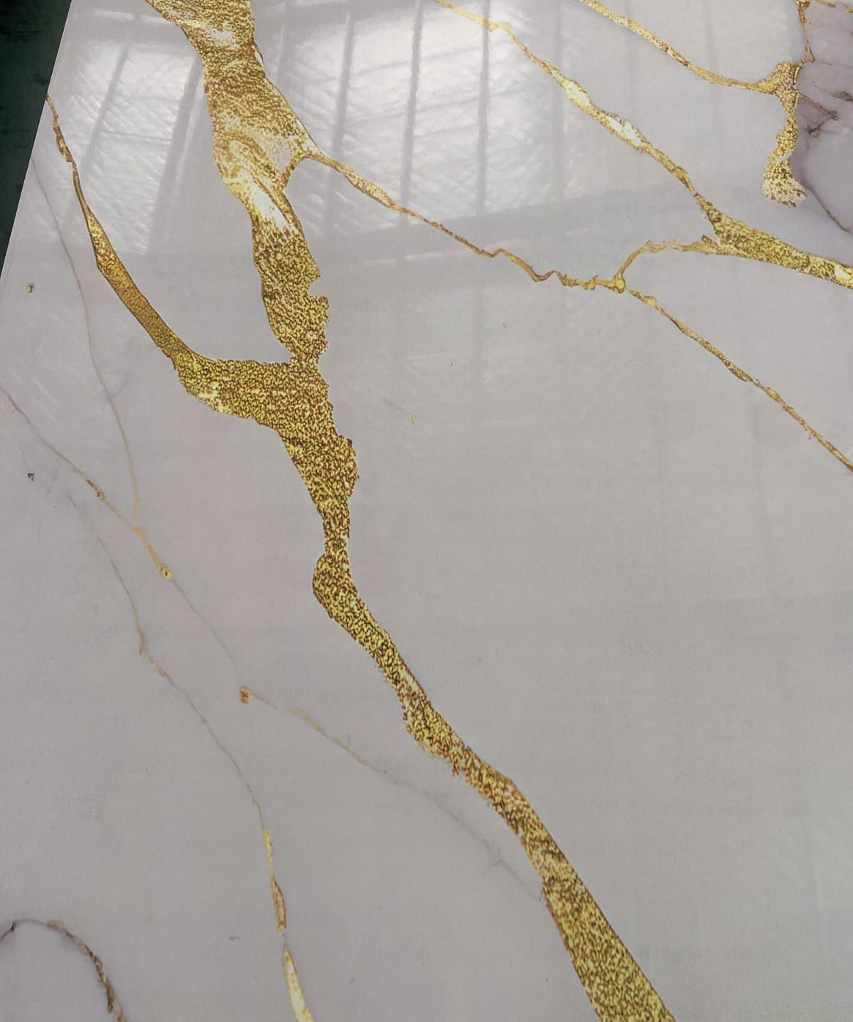 Un primer plano de una encimera de mármol blanco con una franja dorada.