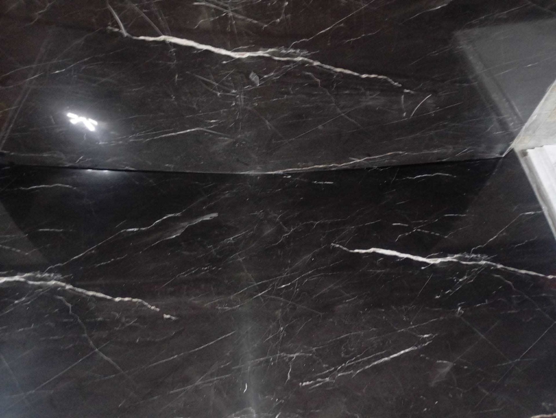 Un primer plano de un suelo de mármol negro con vetas blancas.