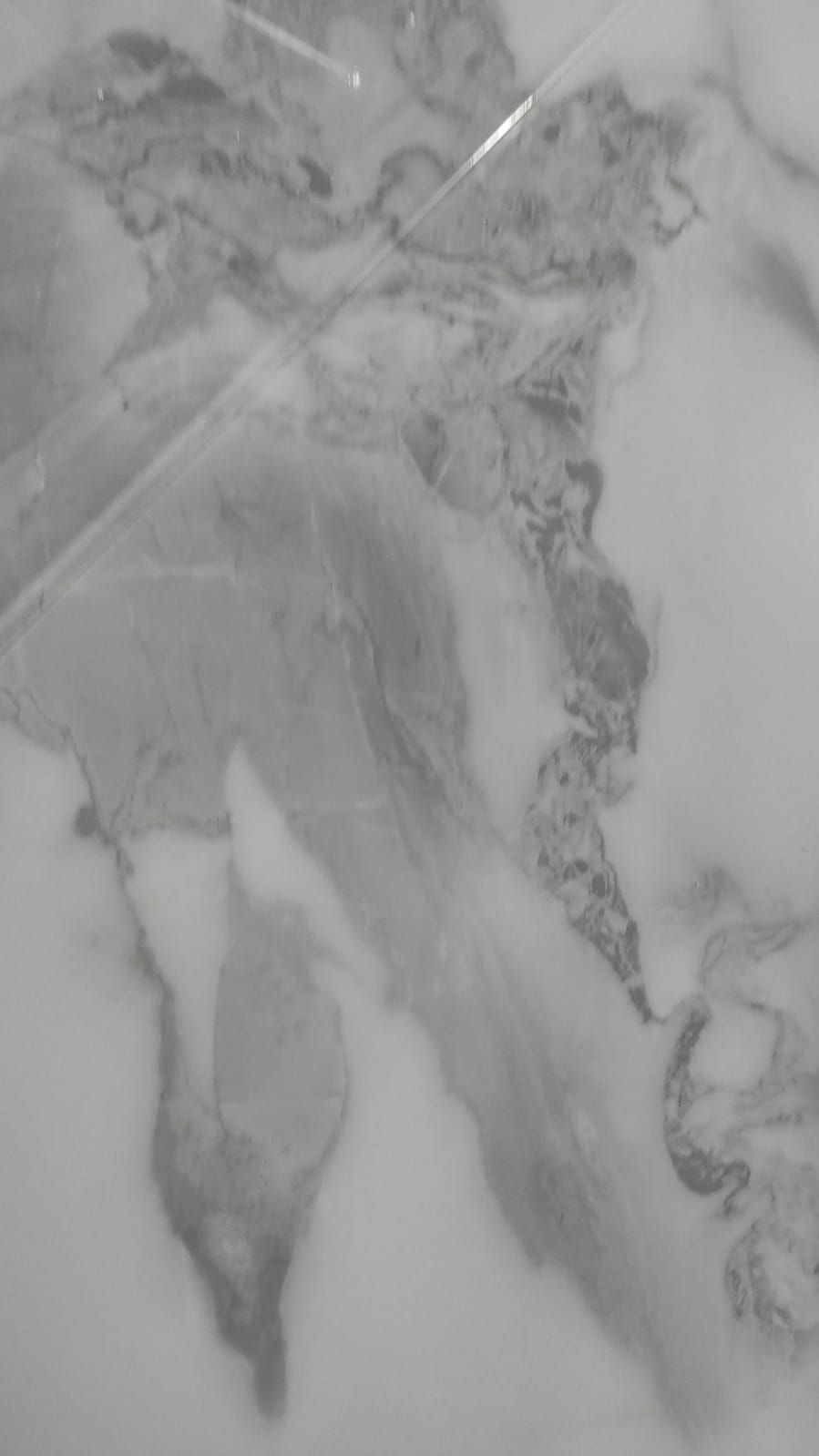 Una fotografía en blanco y negro de un mapa del mundo sobre un suelo de baldosas.