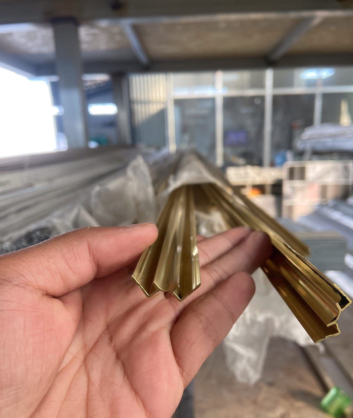 Una persona sostiene un trozo de latón en su mano.