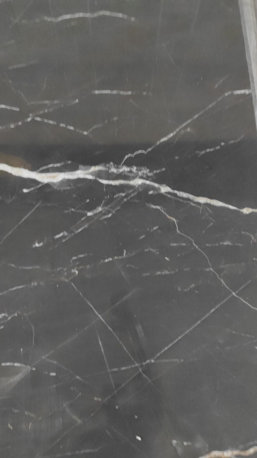 Un primer plano de una baldosa de mármol negro con vetas blancas.