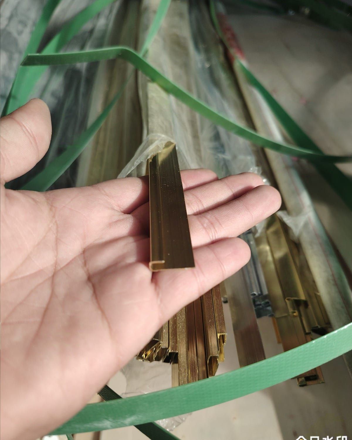 Una persona sostiene un trozo de latón en su mano.