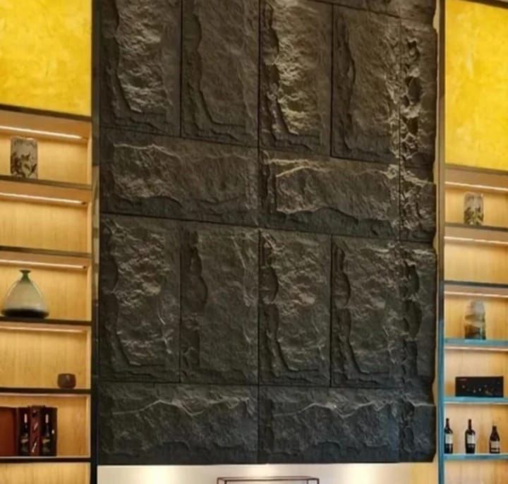 Una habitación con una gran pared de piedra y estantes con botellas.