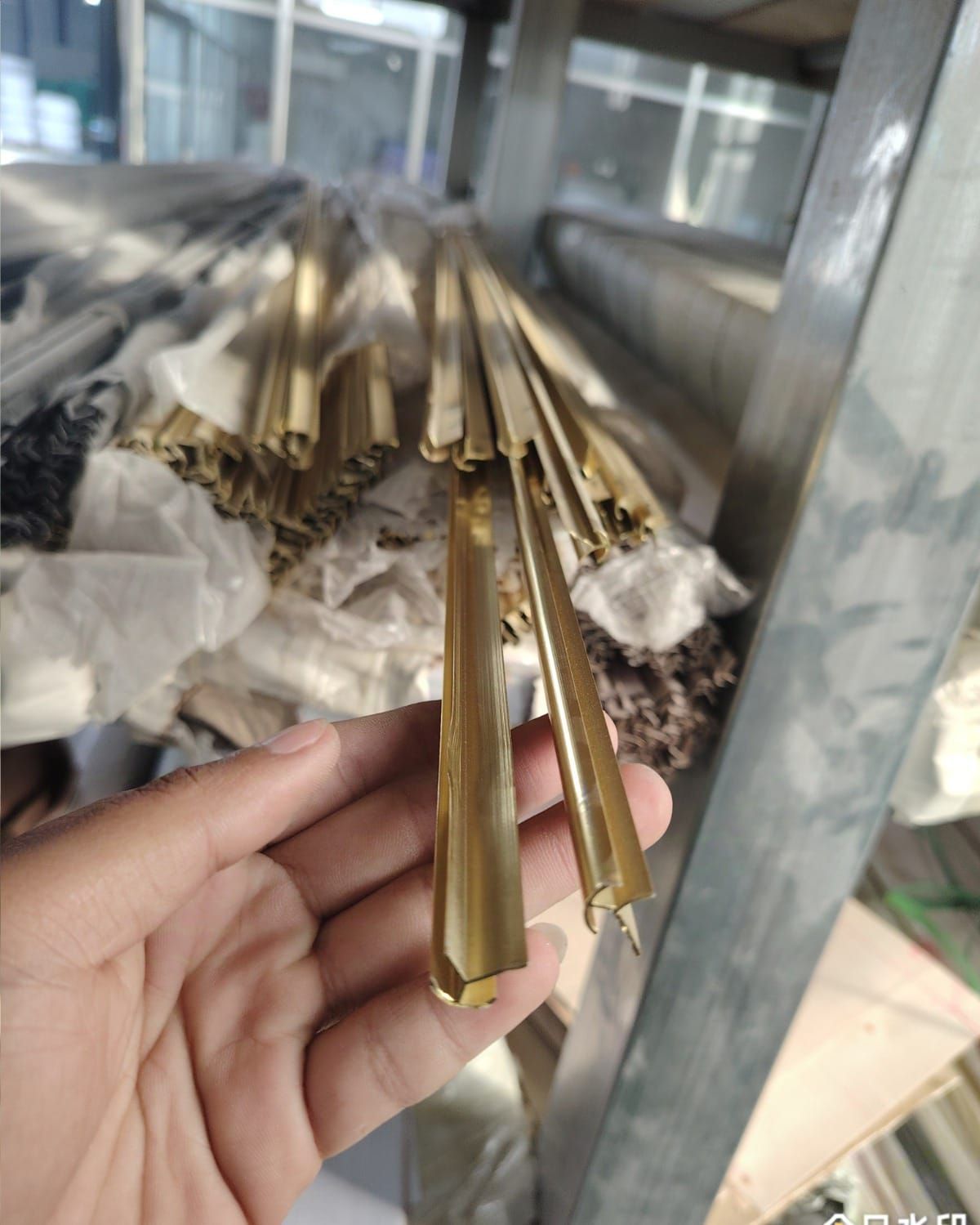 Una persona sostiene un montón de barras de latón en su mano.