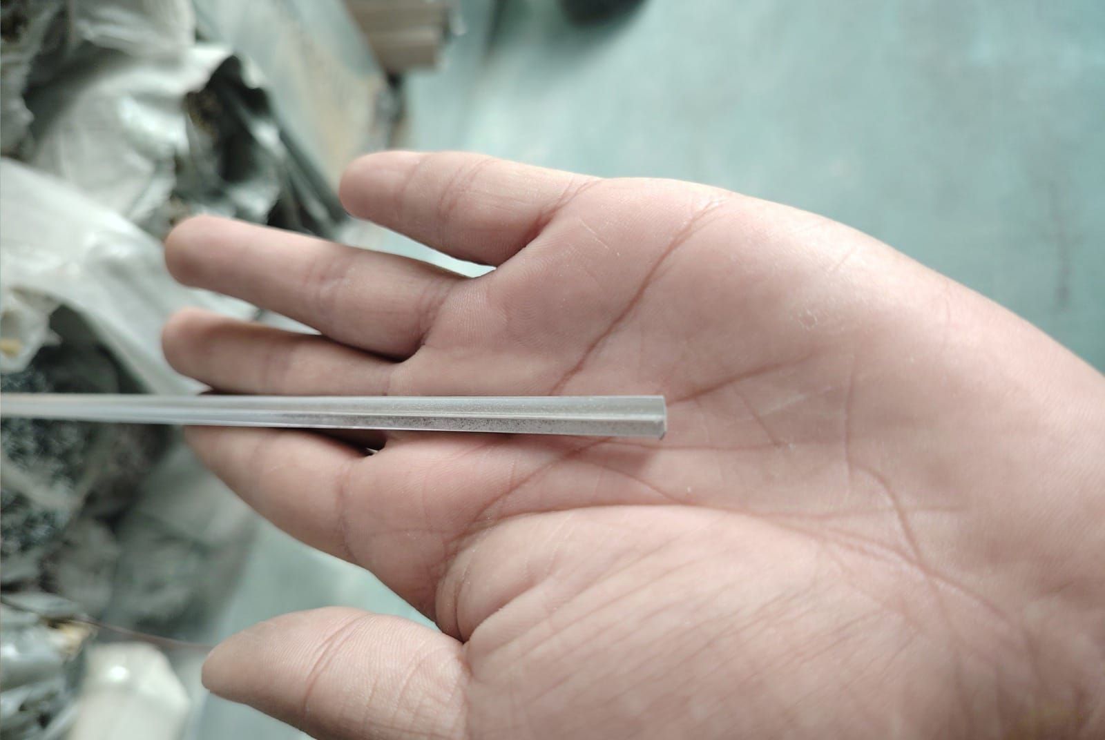 Una persona sostiene un trozo de metal en su mano.