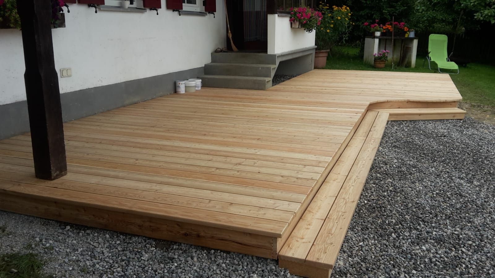 Terrasse aus Holz mit Kiesrand und Pflanzen