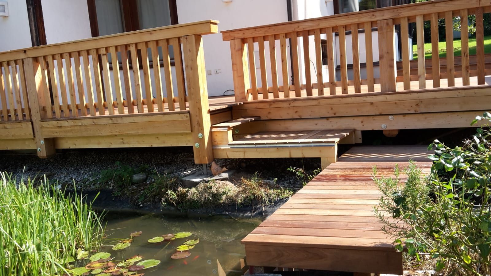 Kleine Brücke mit Geländer über Wasserlauf im Garten