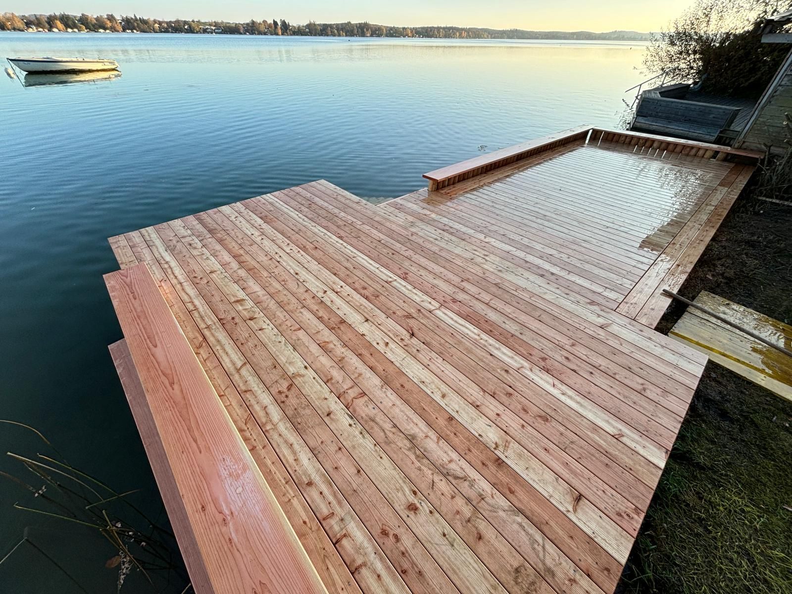Terrasse aus Holz über ruhigem Wasser bei Sonnenlicht