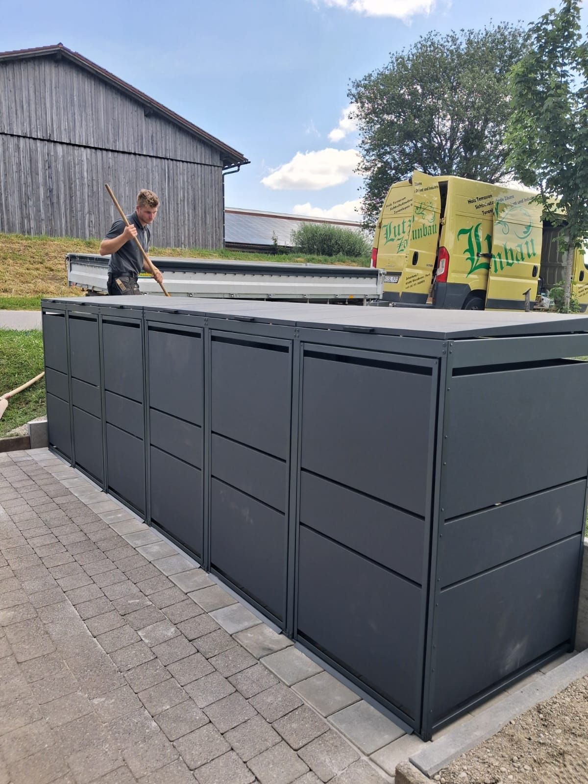 Person arbeitet an Terrasse neben Scheune