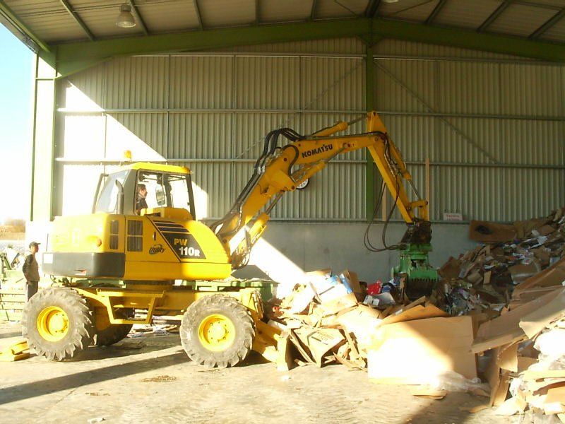 Equipe TGE utilisant une pelle mécanique pour trier des déchets de type carton