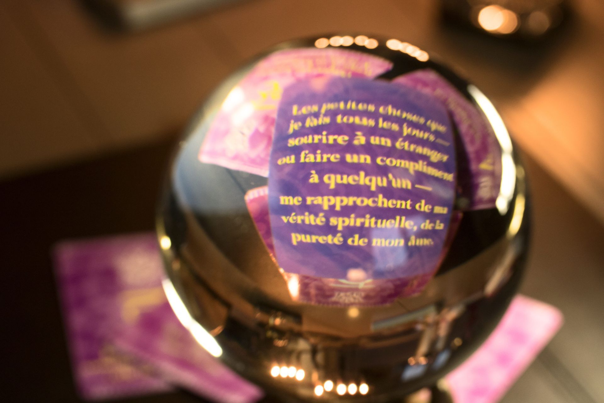 Sphère dorée réfléchissante avec texte français violet sur un fond brun chaud