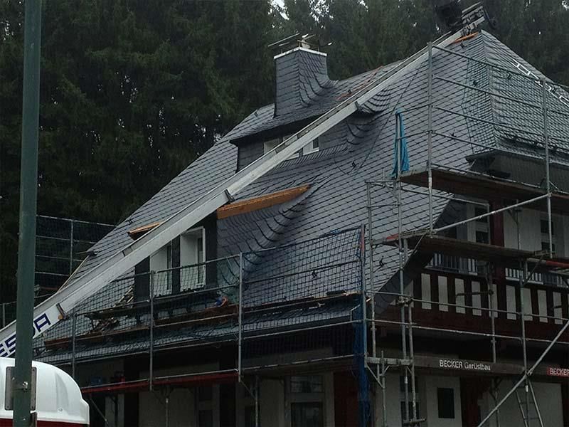 Ein großes Gebäude mit Gerüsten darum und einem Kran auf dem Dach