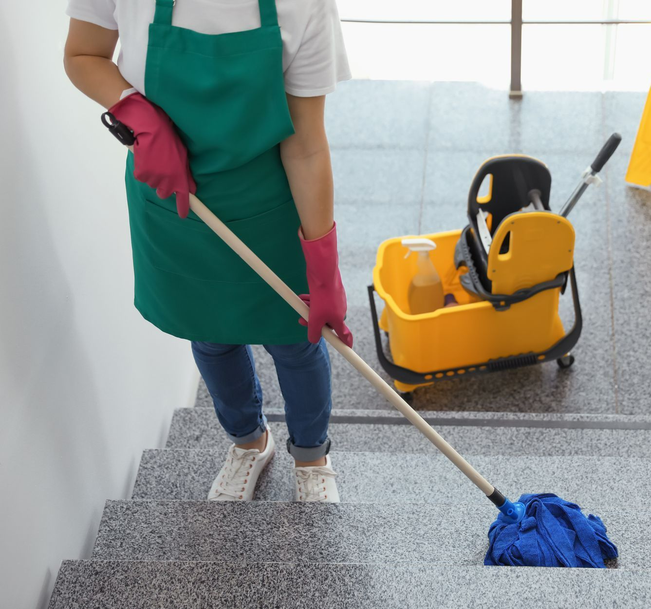 Femme nettoyant des escaliers avec une serpillère