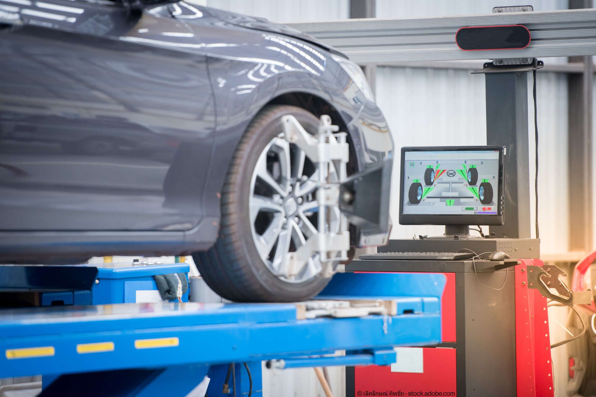 Auto steht auf einer Rampe und auf einem Monitor wird die Ausrichtung der Achsen vermessen