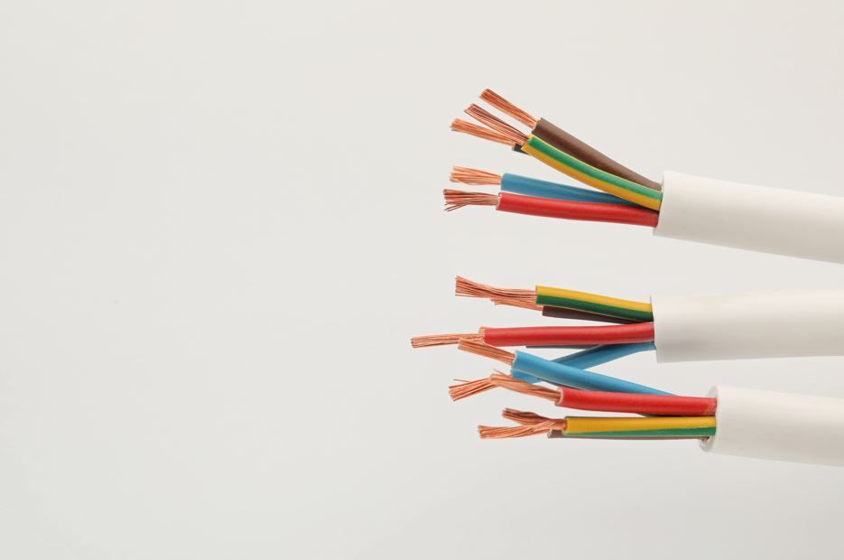 Dos cables eléctricos cortados con múltiples hilos de cobre expuestos en aislamiento rojo, azul, marrón, amarillo y verde.