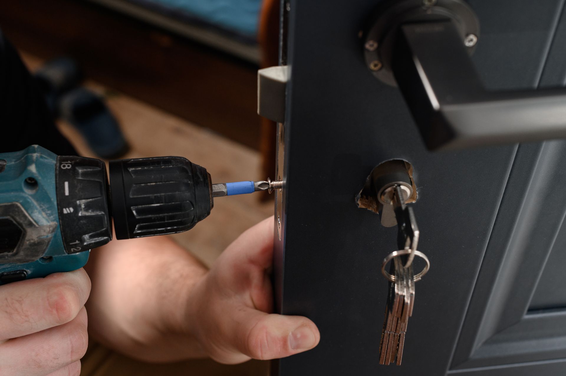 Un menuisier qui installe une nouvelle serrure de porte