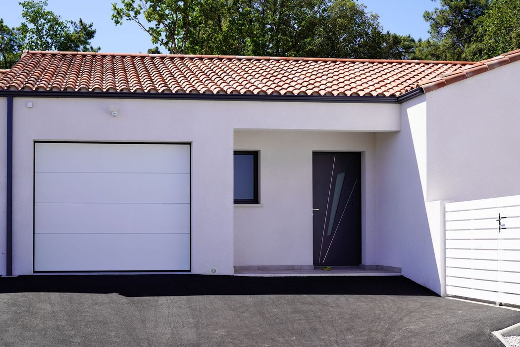 Une maison avec une porte de garage, une fenêtre et une porte d'entrée