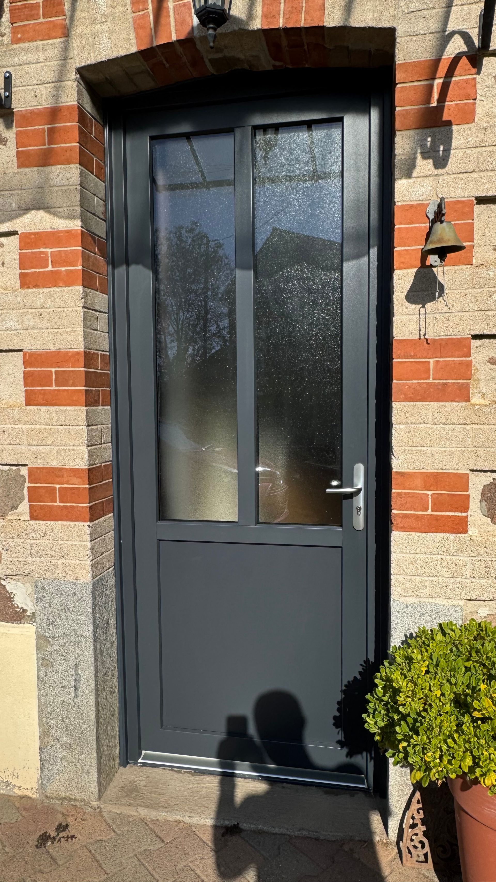 Une porte d'entrée vitrée, en aluminium