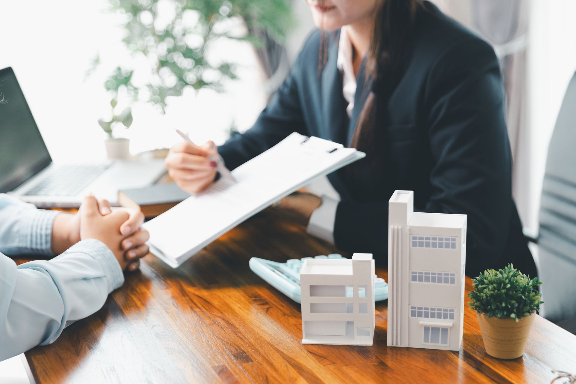 Réunion professionnelle avec signature de document et maquettes de bâtiments