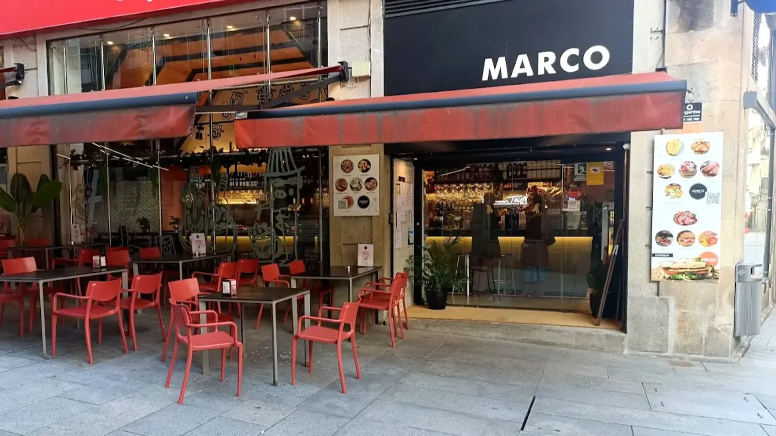 Exterior del restaurante Marco con asientos al aire libre y toldo rojo.