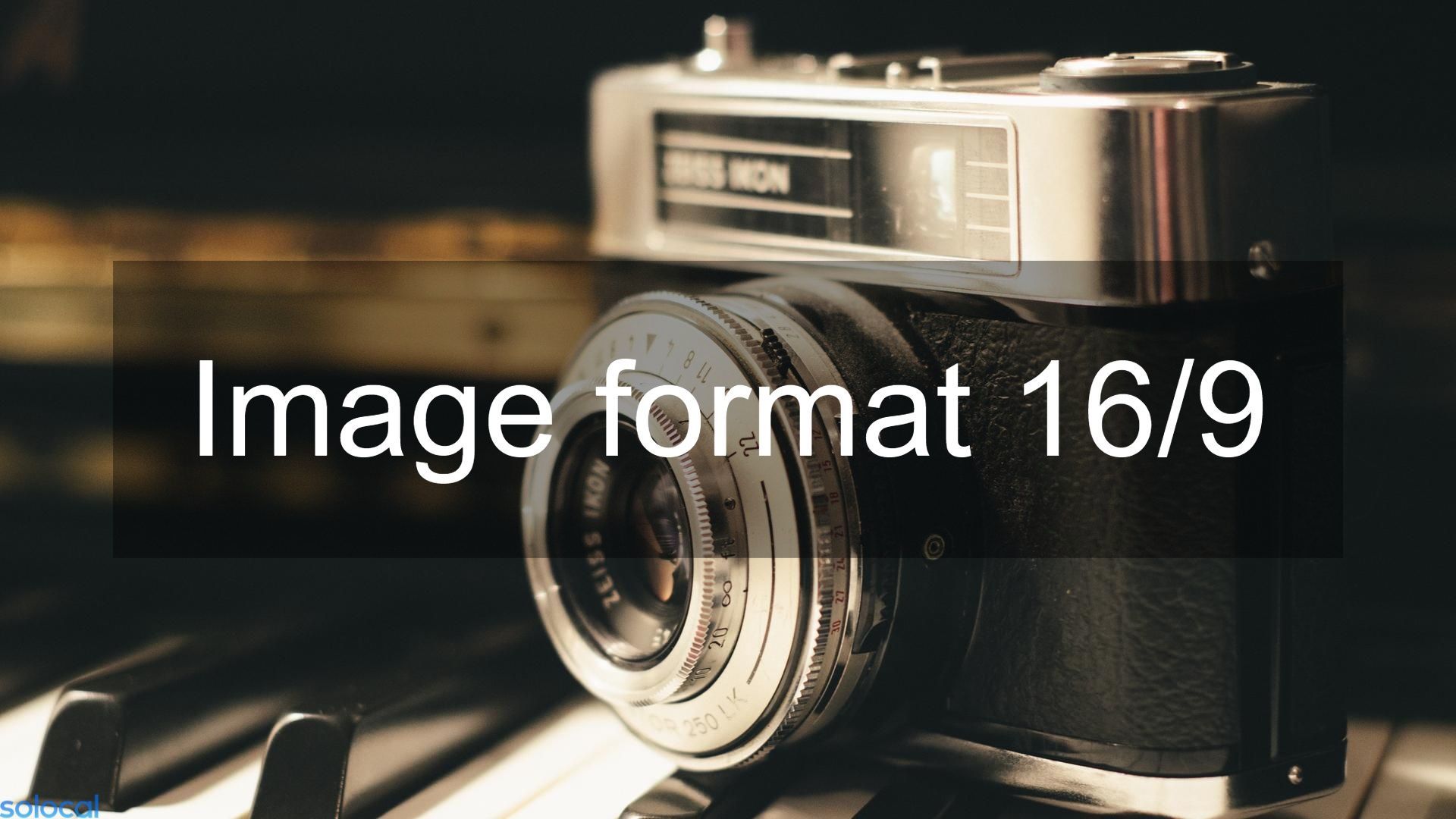 Appareil photo vintage posé sur une table avec un éclairage chaleureux et une inscription indiquant « Format d'image 16/9 ».
