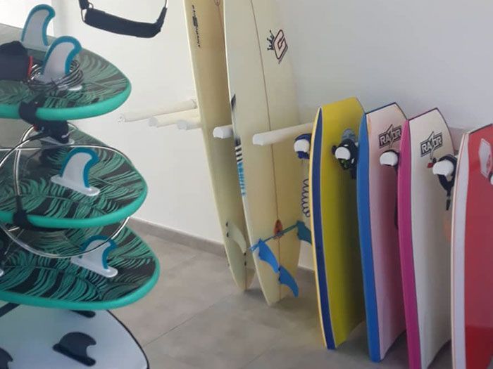 Un montón de tablas de surf están alineadas en una habitación.
