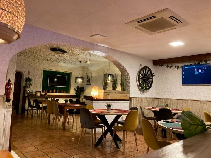 Un restaurante con mesas y sillas y un reloj en la pared.