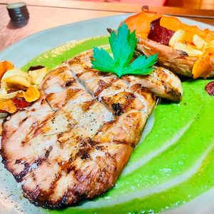 Un primer plano de un plato de comida con carne y verduras sobre una mesa.