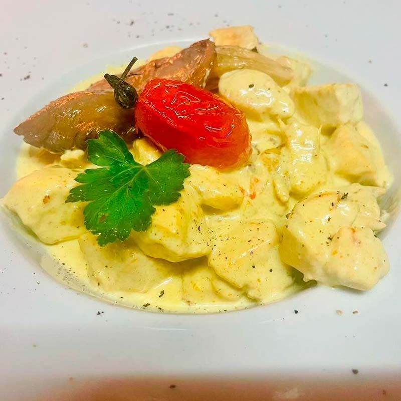 Un primer plano de un plato de comida con tomates y perejil sobre una mesa.