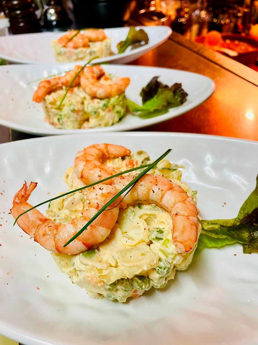 Un primer plano de un plato de comida con camarones en una mesa.