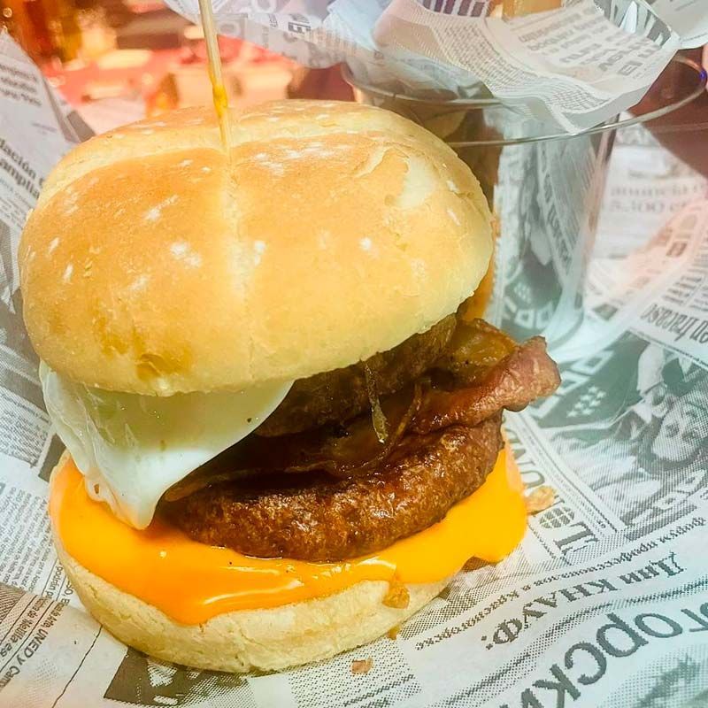 Una hamburguesa con queso y tocino en un pan