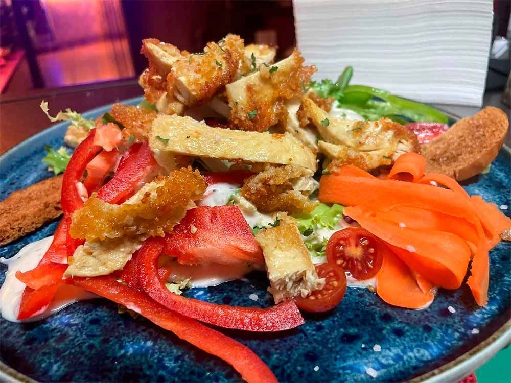 Un primer plano de un plato de comida con verduras en una mesa.