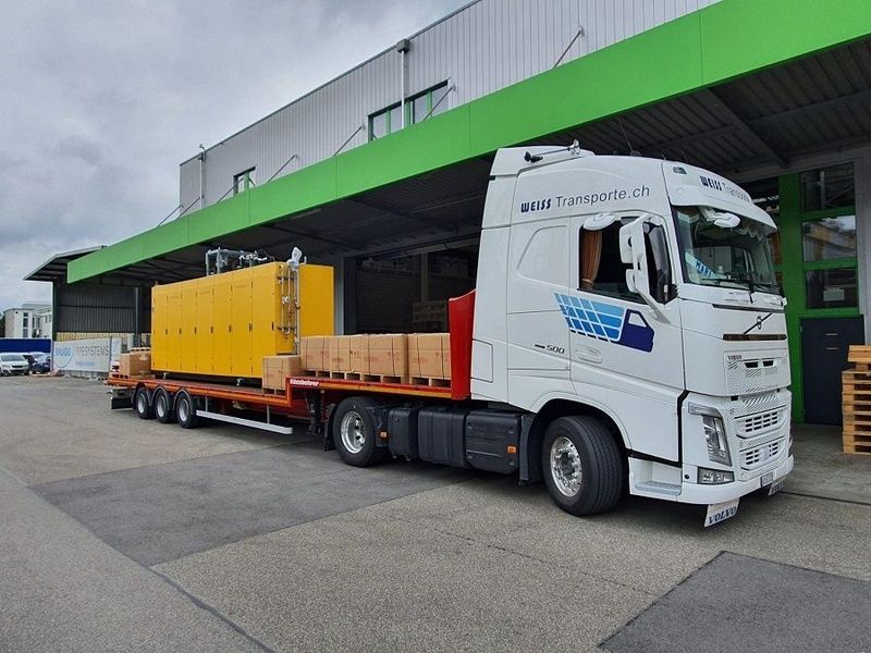 Ein weisser Sattelschlepper parkt vor einem grünen Gebäude. Foto von der Weiss Transporte AG.