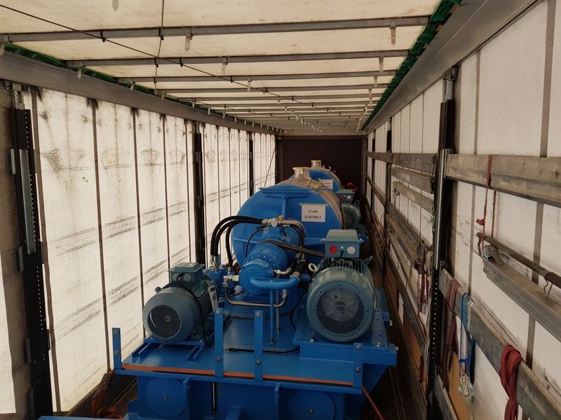 Auf der Ladefläche eines Lastwagens steht eine grosse blaue Maschine. Foto von der Weiss Transporte AG.