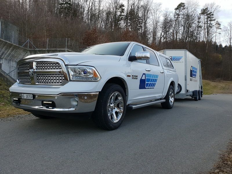 Ein weisser Fahrzeug mit Anhänger steht am Strassenrand. Foto von der Weiss Transporte AG.