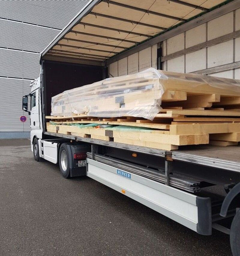 Ein Lkw transportiert einen grossen Stapel Holzpaletten. Foto von der Weiss Transporte AG.