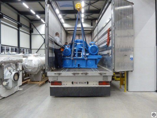 Eine blaue Maschine wird in einen Lkw gehoben. Foto von der Weiss Transporte AG.