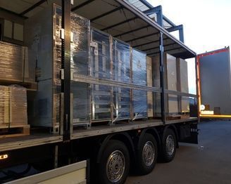 Ein Sattelschlepper wird mit Kisten und Paletten beladen. Foto von der Weiss Transporte AG.