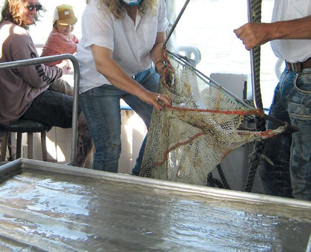 Ein Mann hält eine Schlange, während eine Frau ein Fischernetz hält