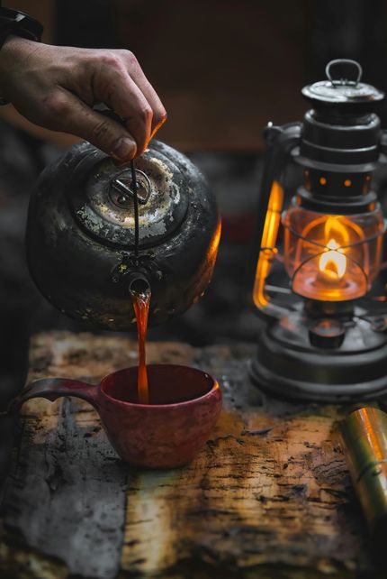 Eine Frau gießt eine Tasse Tee aus einer Teekanne