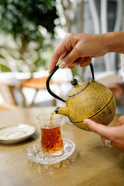 Eine Frau sitzt auf einem Stuhl und hält eine Tasse Tee