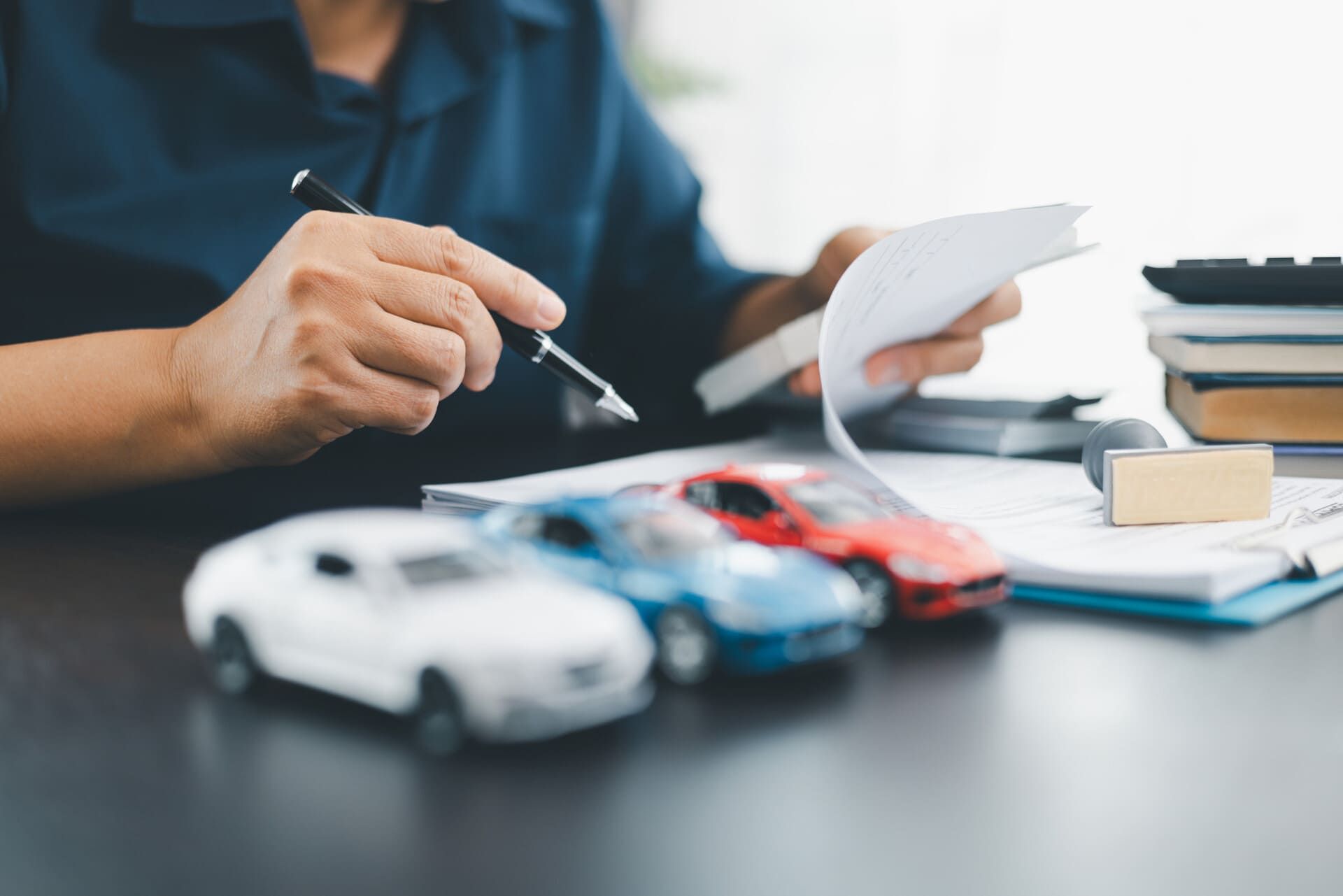 Un hombre está sentado en un escritorio mirando un trozo de papel.