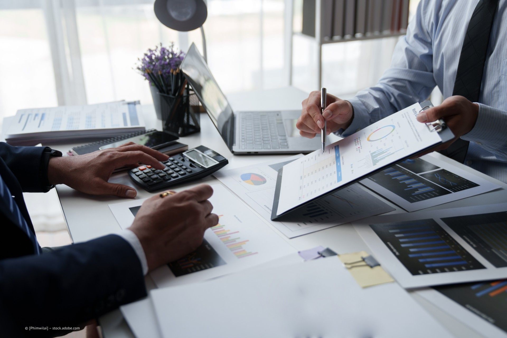 Peter Lennartz Steuerberater – zwei Personen mit Taschenrechner und Finanzdaten an einem Schreibtisch