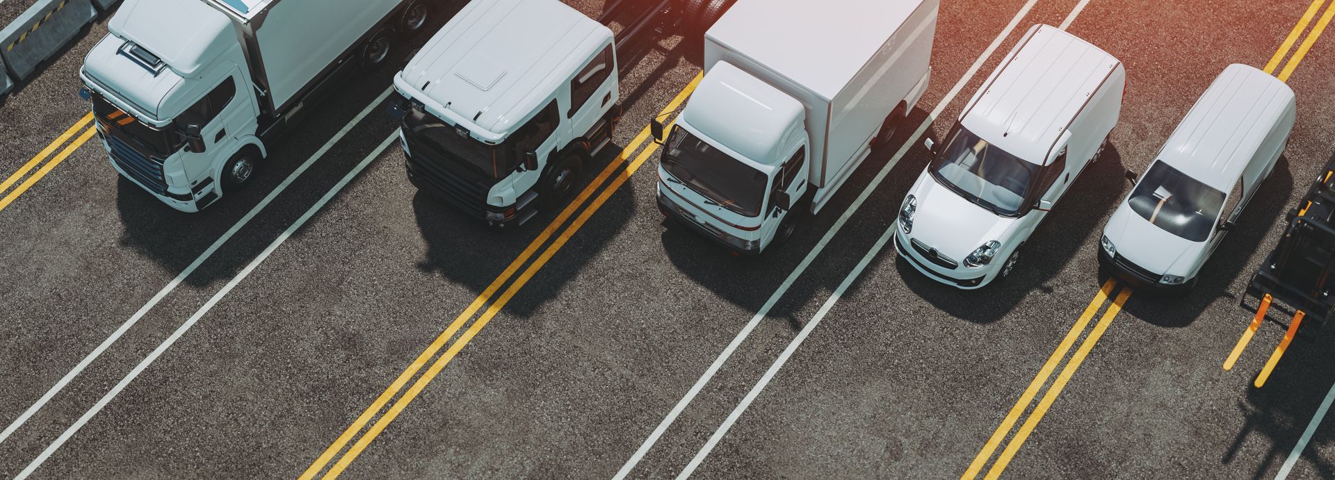 Vogelperspektive weißer LKWs und Transporter auf Parkplatz